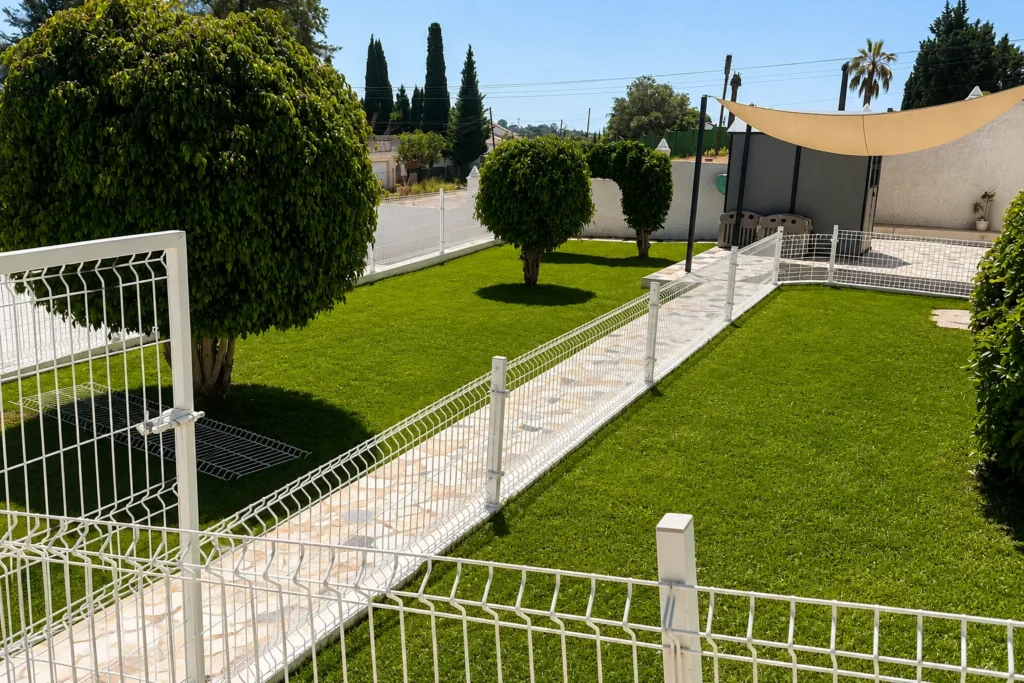 Jardín exterior seguro para perros en Marbella Dog Club con césped natural y zonas diferenciadas.